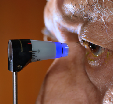 Eye being examined with an applanation tonometry device forshowing symptoms like blurring of vision and seeing black dots